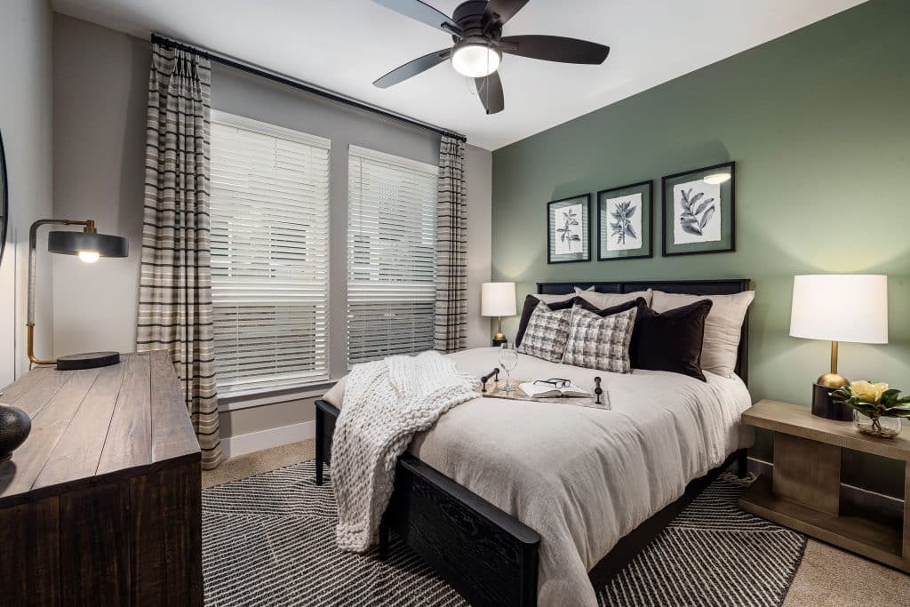 Carpeted Bedroom with large windows, ceiling fans and blinds